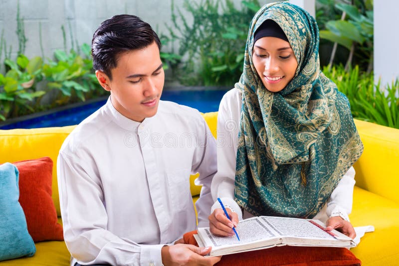 Couples musulmans asiatiques lisant ensemble Coran ou le Quran images stock Couples musulmans asiatiques lisant ensemble Coran ou le Quran images stock