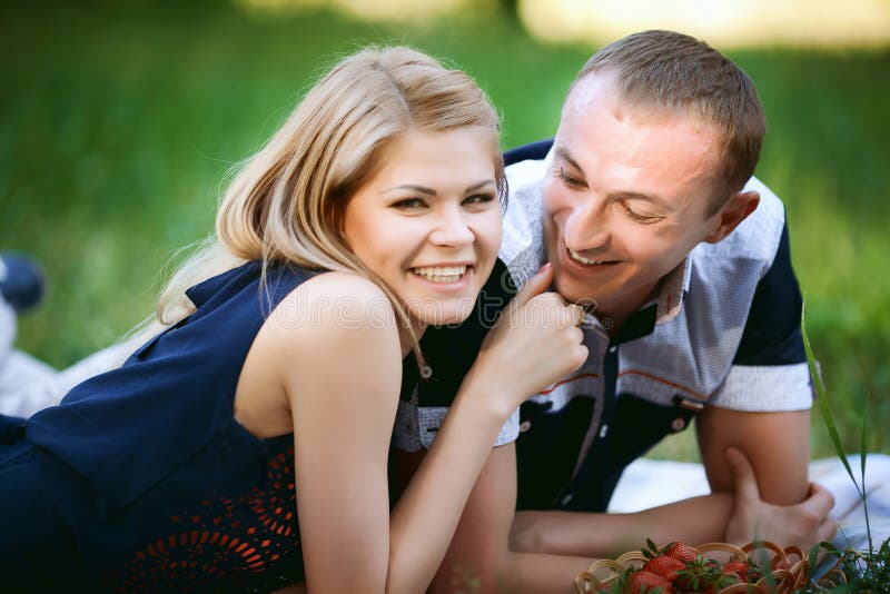 Couples se situant dans l'herbe photos stock Couples se situant dans l'herbe photos stock
