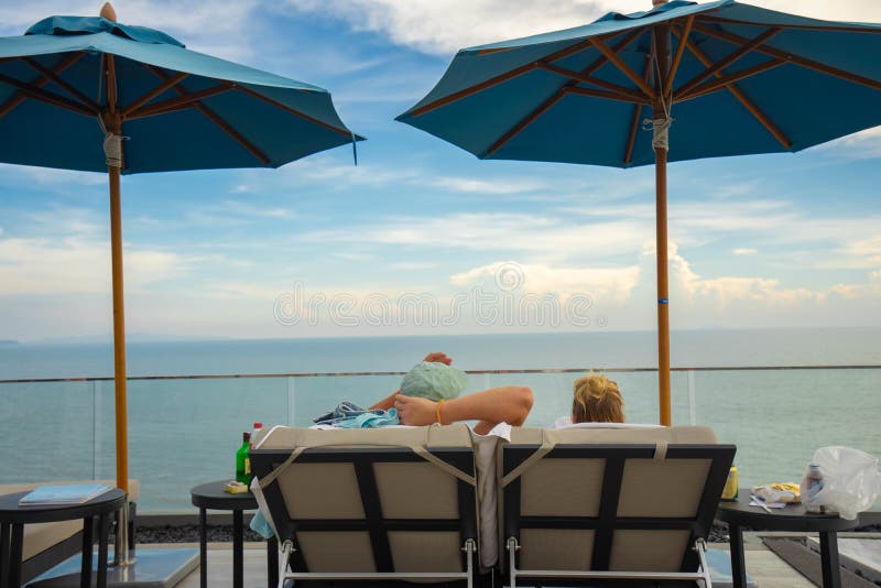 Couples sitting together by the swimming pool. Vacation and relaxation concepts stock photo Couples sitting together by the swimming pool. Vacation and relaxation concepts stock photo