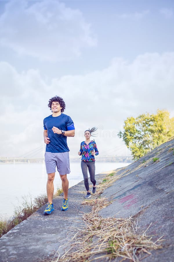 Couples sportifs fonctionnant et pulsant photo stock Couples sportifs fonctionnant et pulsant photo stock