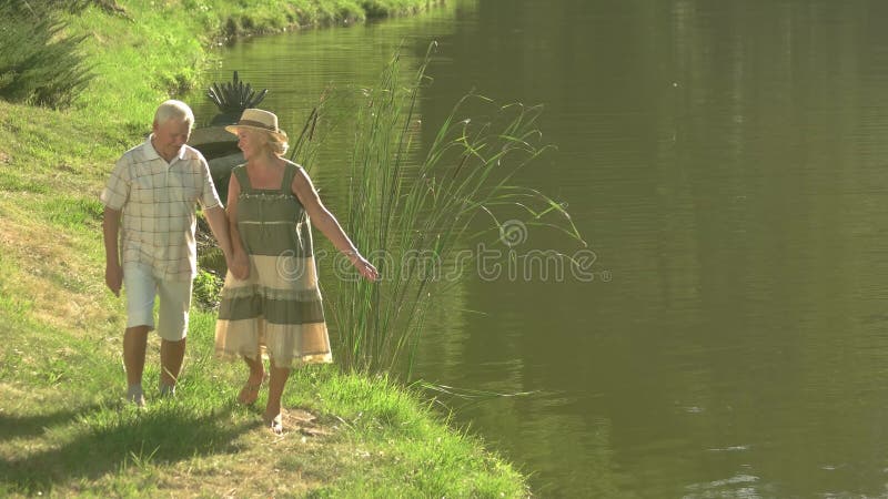 Couples supérieurs appréciant la nature près de l'eau