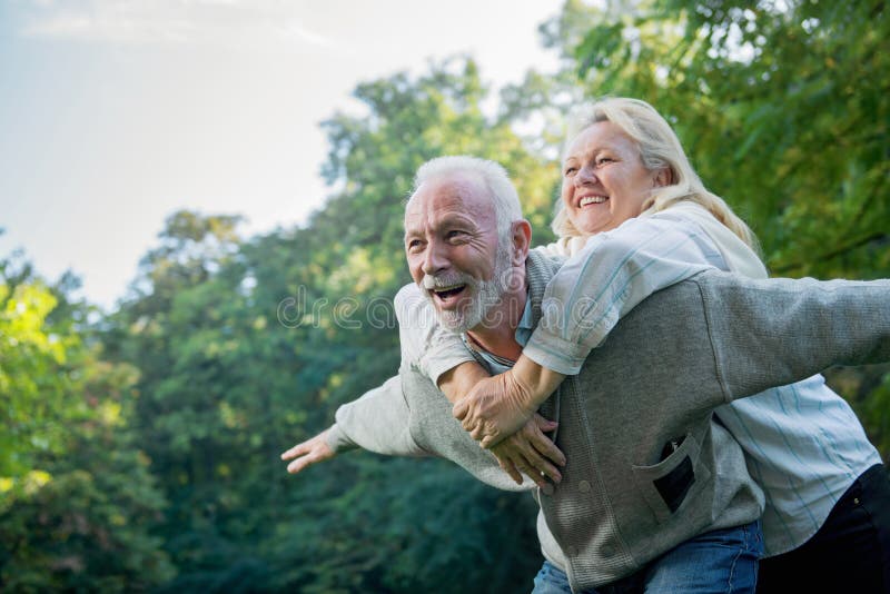 Couples supérieurs heureux souriant dehors en nature image libre de droits