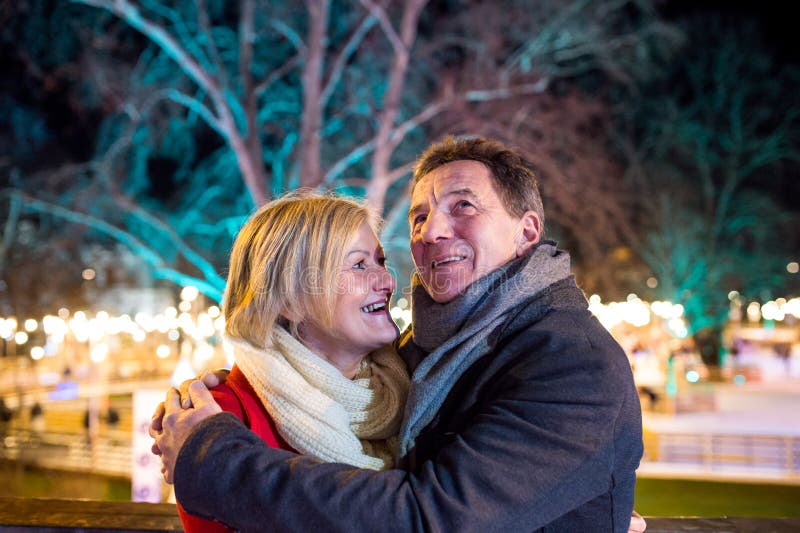 Couples supérieurs marchant dans la ville de nuit Hiver, bâtiment historique photos libres de droits Couples supérieurs marchant dans la ville de nuit Hiver, bâtiment historique photos libres de droits