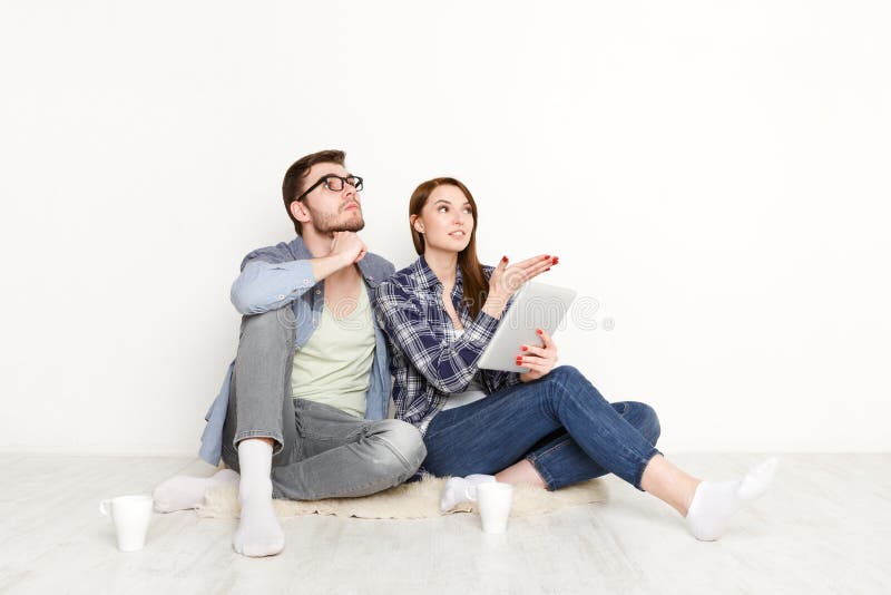 Couples sélectionnant des meubles en ligne pour le nouvel appartement photographie stock Couples sélectionnant des meubles en ligne pour le nouvel appartement photographie stock