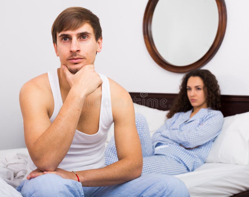 Couples triant des relations dans le lit images stock Couples triant des relations dans le lit images stock
