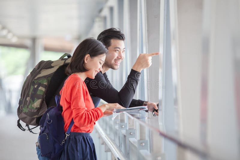 Couples of younger traveling man and woman looking to traveler g