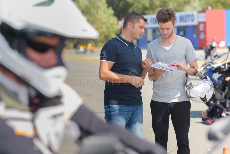 Couples à côté de moto image stock Couples à côté de moto image stock