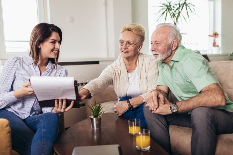 Couples âgés consultant avec l'agent d'assurance image stock