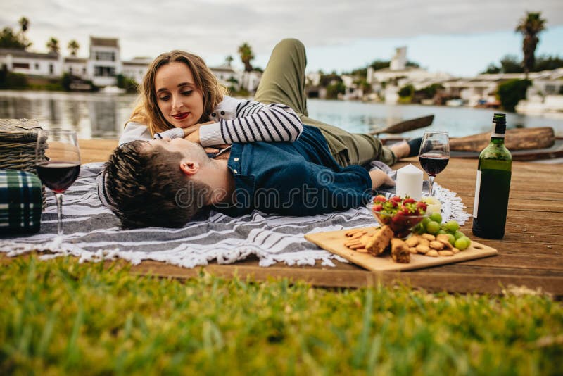 Couplez apprécier leur date près d'un lac photographie stock libre de droits Couplez apprécier leur date près d'un lac photographie stock libre de droits
