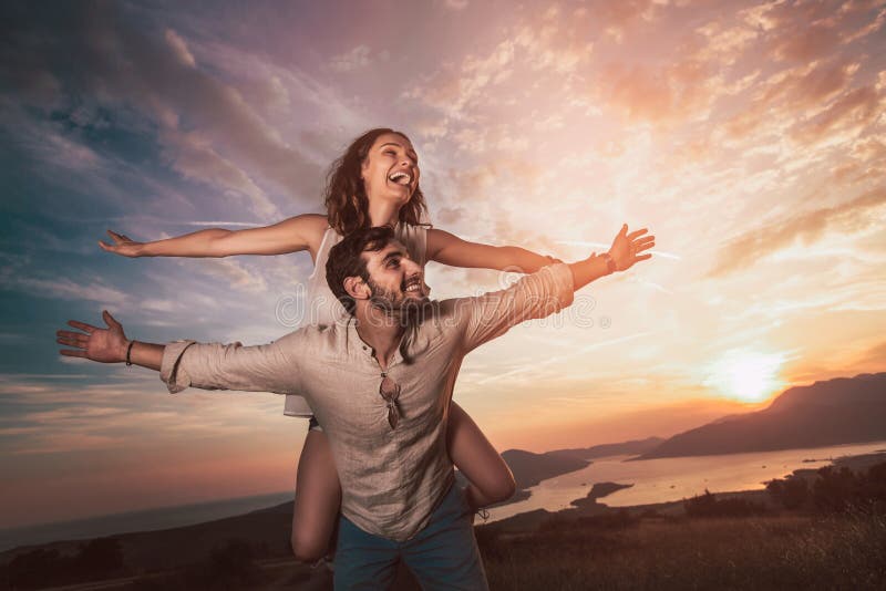 Couplez avoir avoir l'amusement en nature, derrière eux est un beau coucher du soleil au-dessus de baie de Boka photo stock Couplez avoir avoir l'amusement en nature, derrière eux est un beau coucher du soleil au-dessus de baie de Boka photo stock