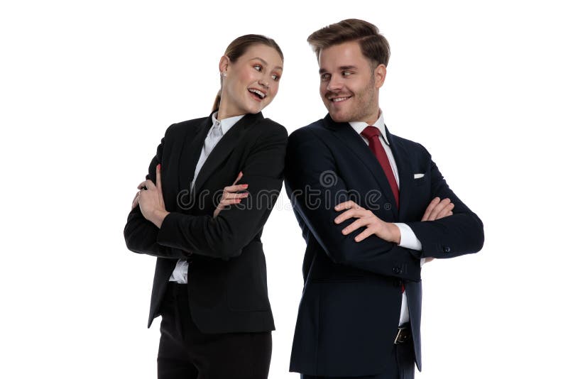 Couplez dans des costumes se tenant de nouveau au dos photo stock Couplez dans des costumes se tenant de nouveau au dos photo stock