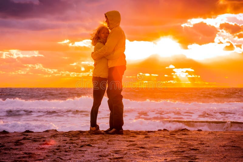 Couplez l'homme et la femme étreignant dans l'amour restant sur le bord de la mer de plage photographie stock libre de droits Couplez l'homme et la femme étreignant dans l'amour restant sur le bord de la mer de plage photographie stock libre de droits