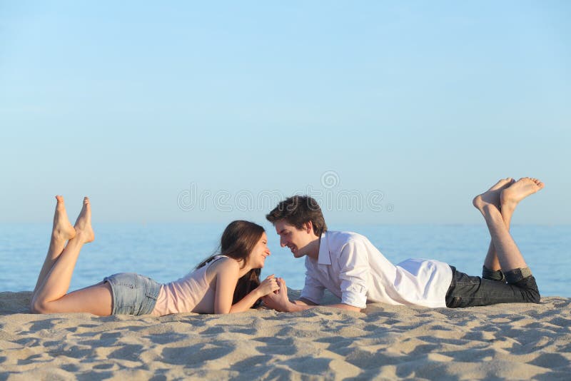 Couplez la datation et le repos sur le sable de plage photo stock Couplez la datation et le repos sur le sable de plage photo stock