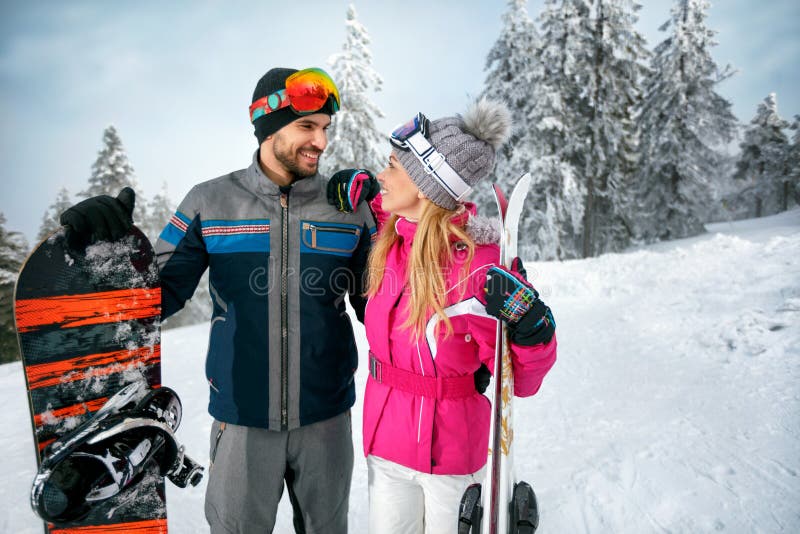 Couplez le ski et le snowboarding appréciant dans le toget neigeux de montagnes photos libres de droits Couplez le ski et le snowboarding appréciant dans le toget neigeux de montagnes photos libres de droits