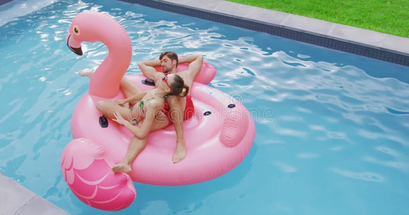 Couplez le sommeil ensemble sur le tube gonflable dans la piscine 4k banque de vidéos
