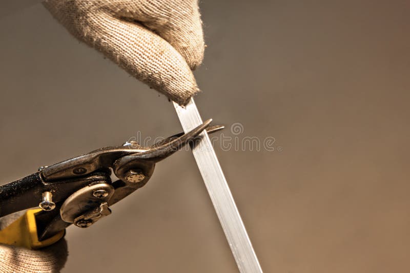Coupure du rail en métal avec des ciseaux manuels industriels puissants avec des mains images stock Coupure du rail en métal avec des ciseaux manuels industriels puissants avec des mains images stock