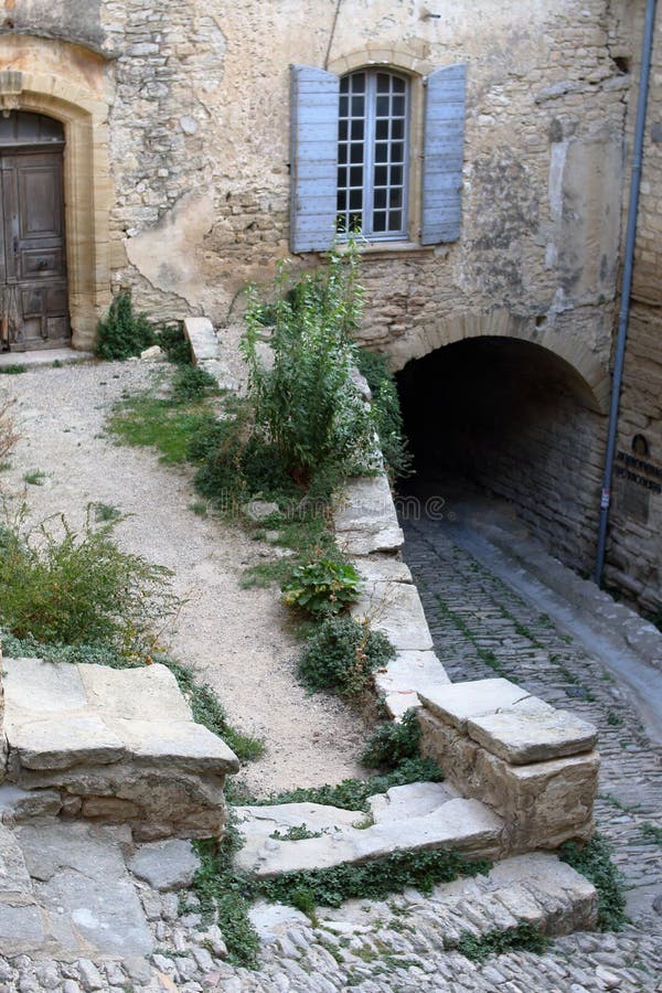 Cour en pierre à trois nivaux avec une voûte et une vieille fenêtre photo stock Cour en pierre à trois nivaux avec une voûte et une vieille fenêtre photo stock