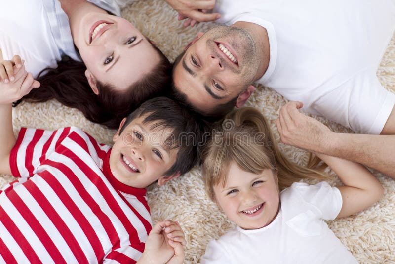 High angle of family on floor with heads together in a circle. High angle of family on floor with heads together in a circle