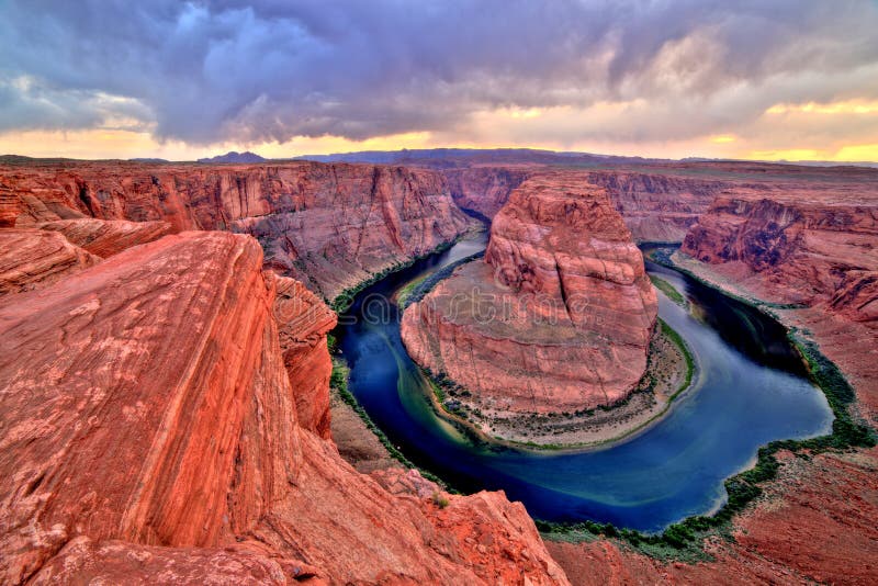 Courbure en fer à cheval sur le fleuve Colorado au coucher du soleil et au temps nuageux, Utah photo stock Courbure en fer à cheval sur le fleuve Colorado au coucher du soleil et au temps nuageux, Utah photo stock
