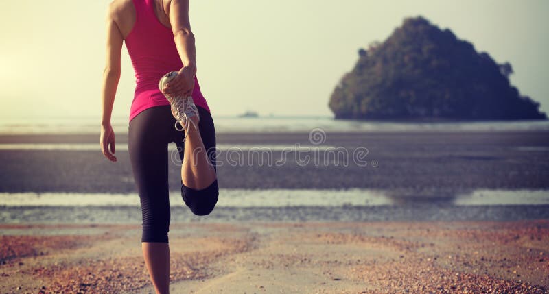 Coureur de femme étirant des jambes avant le fonctionnement image libre de droits Coureur de femme étirant des jambes avant le fonctionnement image libre de droits