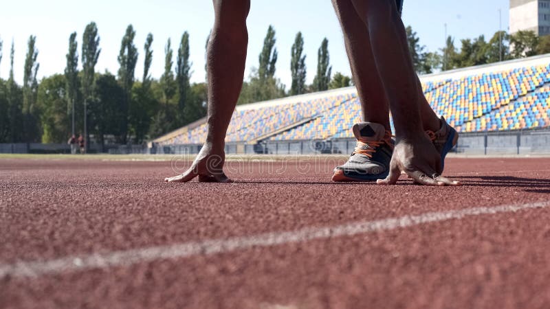 Coureur en position de départ sur la voie, formation de sportif avant la concurrence photographie stock libre de droits Coureur en position de départ sur la voie, formation de sportif avant la concurrence photographie stock libre de droits