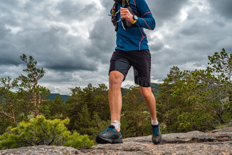 Coureur masculin fonctionnant sur une traînée de montagne photographie stock libre de droits Coureur masculin fonctionnant sur une traînée de montagne photographie stock libre de droits