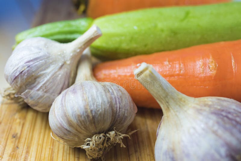 Courgette en wortelen en hoofd 3 van knoflook op een scherpe raad royalty-vrije stock afbeeldingen Courgette en wortelen en hoofd 3 van knoflook op een scherpe raad royalty-vrije stock afbeeldingen