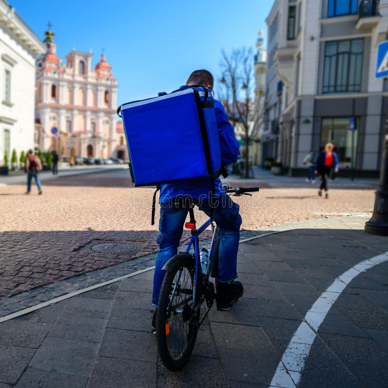 Courier On Bicycle Delivering Food In European City