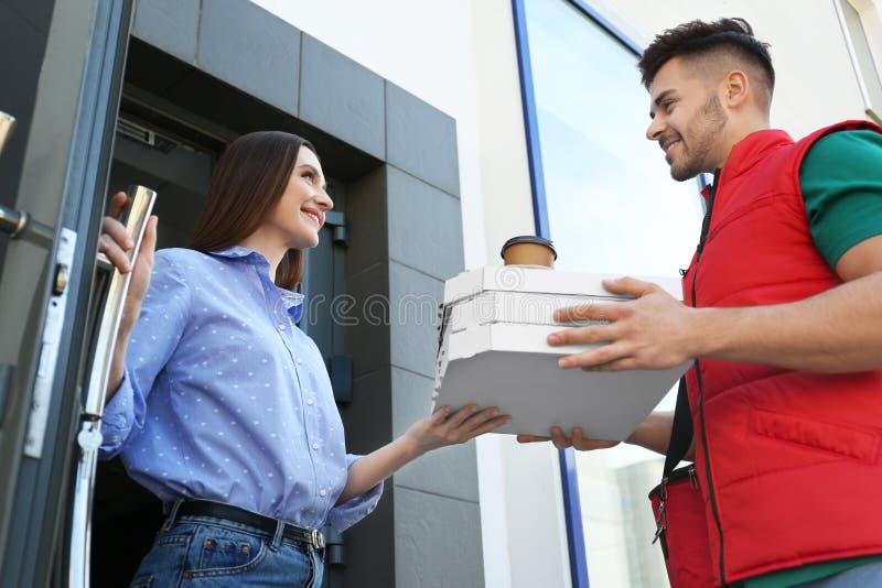 Courier giving order to young woman at open door royalty free stock photos Courier giving order to young woman at open door royalty free stock photos