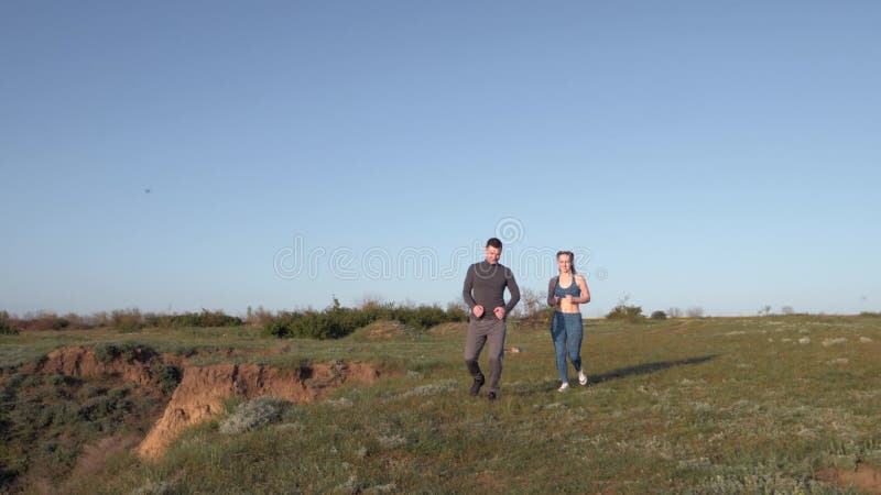 Courir dans la nature, joyeux sportif avec jogging sportif en plein soleil après un entraînement cardio contre le ciel bleu