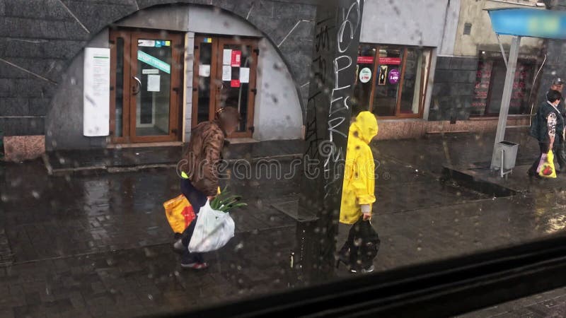 Course de personnes à partir de la vue des transports en commun d'arrêt de pluie de la fenêtre un homme sous la pluie jaune travai banque de vidéos