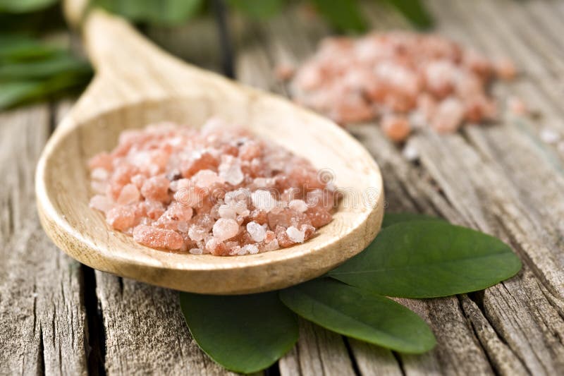 Course pink Himalayan salt on a wooden spoon stock photos