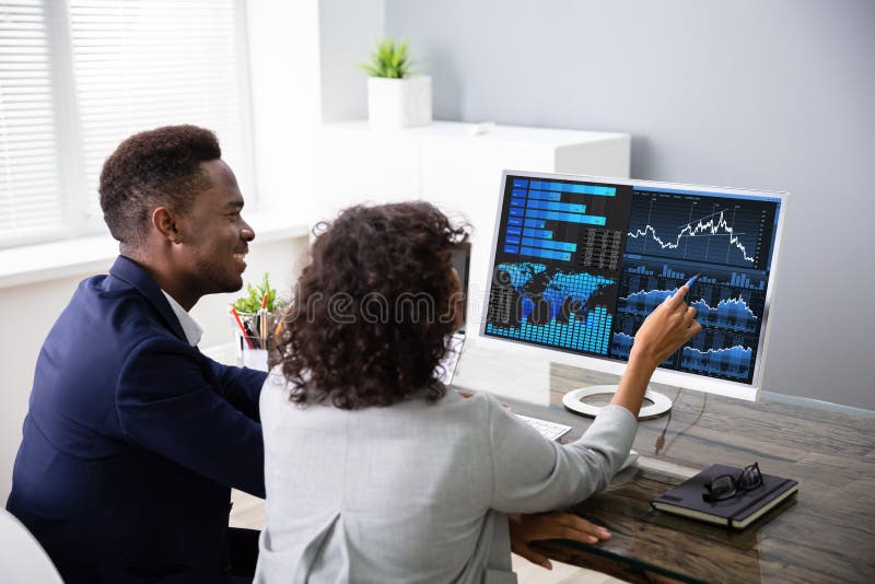 Stock Market Broker Analyzing Graphs On Computer In Office. Stock Market Broker Analyzing Graphs On Computer In Office