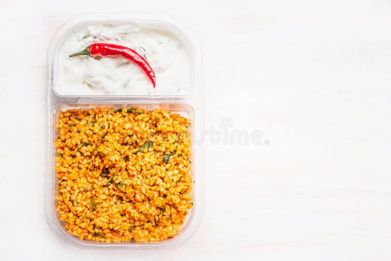 Couscoussallad med yoghurtdoppet i lunchask på vit träbakgrund royaltyfri fotografi Couscoussallad med yoghurtdoppet i lunchask på vit träbakgrund royaltyfri fotografi