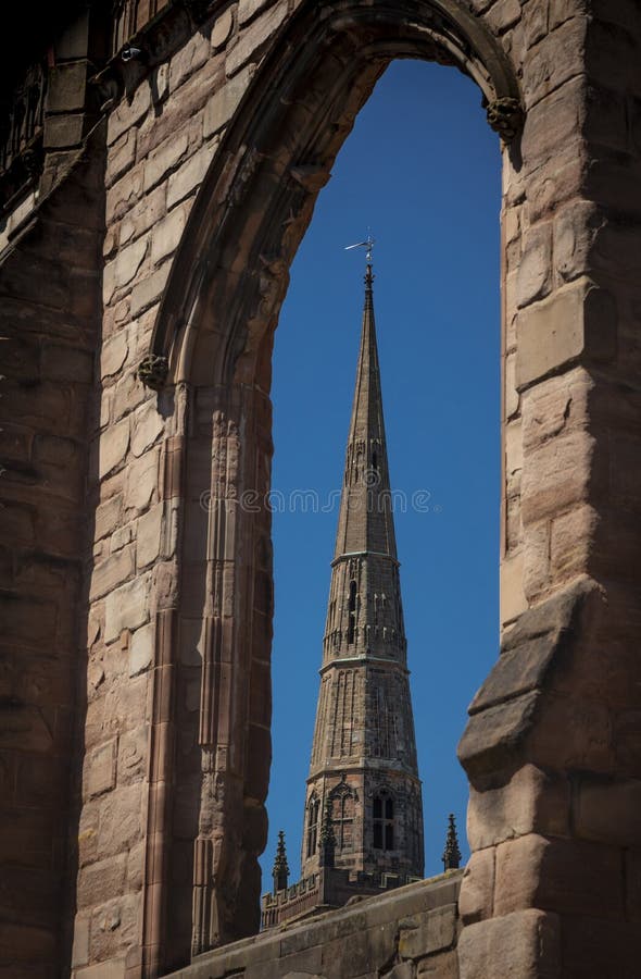 Coventry, Warwickshire, UK, June 27th 2019, spire of Holy Trinity Church seen through a ruined window of Saint Michaels Cathedral. Coventry, Warwickshire, United stock photography Coventry, Warwickshire, UK, June 27th 2019, spire of Holy Trinity Church seen through a ruined window of Saint Michaels Cathedral. Coventry, Warwickshire, United stock photography