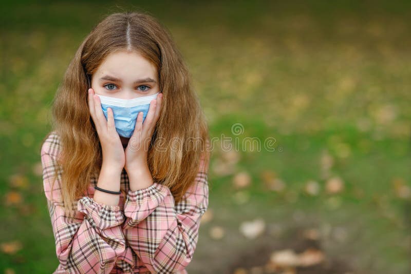 COVID-19 Coronavirus pandemic. Child-girl wearing a mask protecting against the spread of the SARS-CoV-2 virus