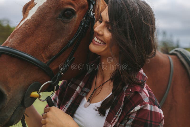 Cow-girl de sourire avec son cheval photos stock Cow-girl de sourire avec son cheval photos stock