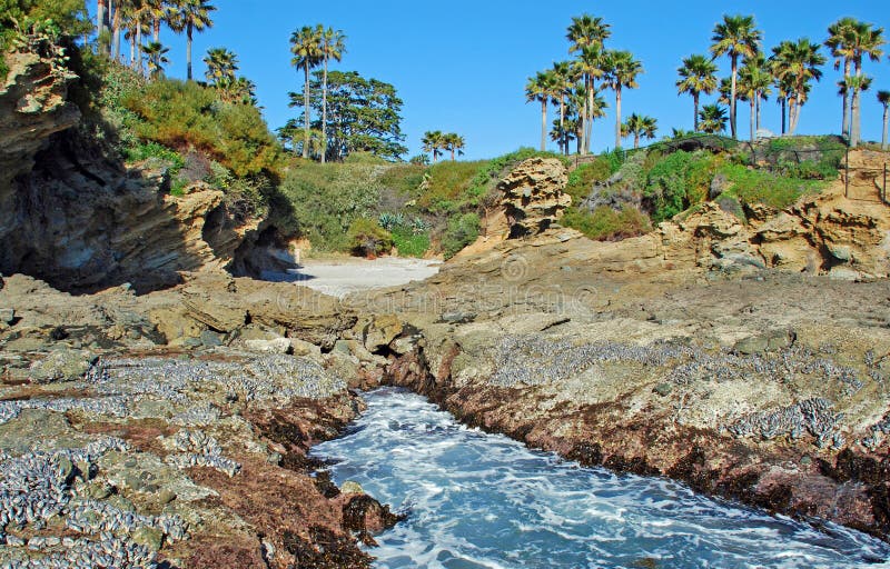 Image shows a small, secluded cove (left center) adjacent and south of Crescent Bay in North Laguna Beach, California. The beach of this cove is not sand but broken sea shells. Origin of the coves name is mysterious. Image shows a small, secluded cove (left center) adjacent and south of Crescent Bay in North Laguna Beach, California. The beach of this cove is not sand but broken sea shells. Origin of the coves name is mysterious.