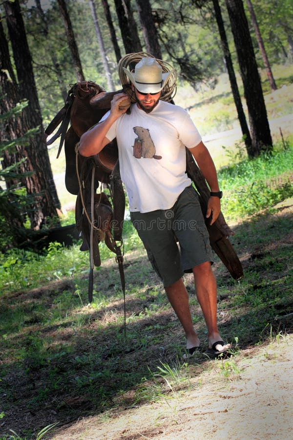 Cowboy con la sella immagine stock Cowboy con la sella immagine stock