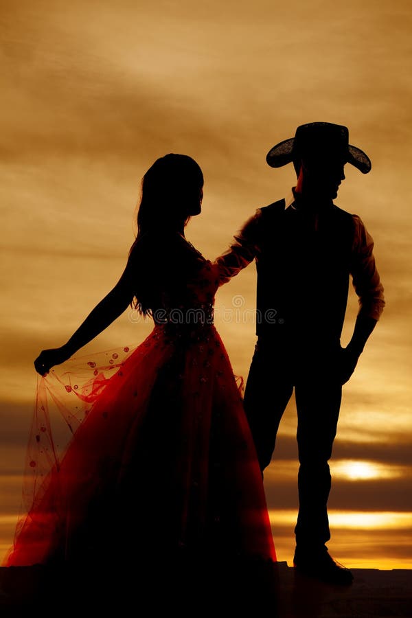 Cowboy e donna della siluetta in vestito immagini stock libere da diritti Cowboy e donna della siluetta in vestito immagini stock libere da diritti