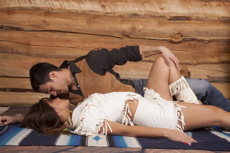 Cowboy and indian woman lay him top almost kiss