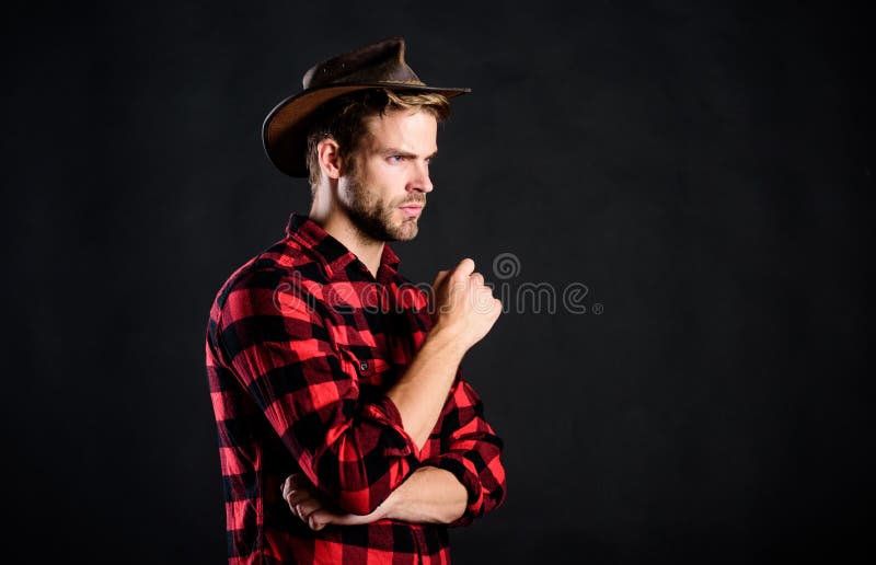 Cowboy life came to be highly romanticized. Man unshaven cowboy black background. Archetypal image of Americans abroad. Masculinity and brutality concept royalty free stock photos Cowboy life came to be highly romanticized. Man unshaven cowboy black background. Archetypal image of Americans abroad. Masculinity and brutality concept royalty free stock photos