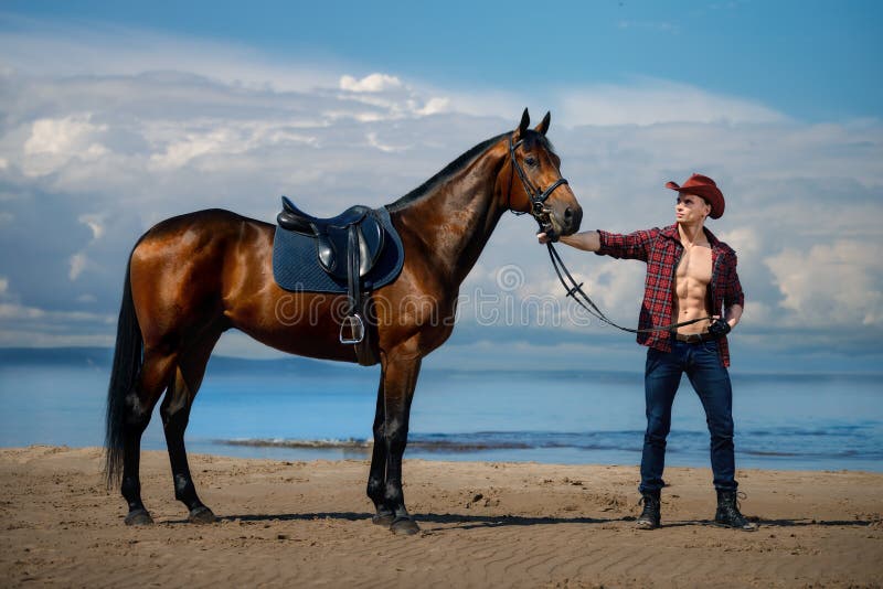 Cowboy och häst för macho man stilig på bakgrunden av himmel och vatten arkivfoto Cowboy och häst för macho man stilig på bakgrunden av himmel och vatten arkivfoto