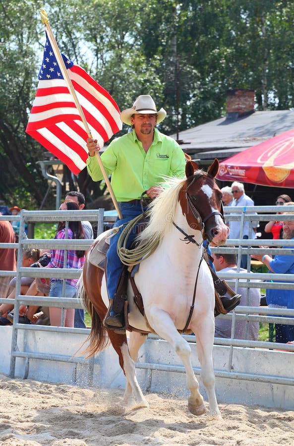 Unidentified Cowboy riding with American flag in a Opening ceremony at The International Rodeo Show Strabag Prorodeo Tour on August 24, 2013. Dnesice Halter Walley Czech Republic. Unidentified Cowboy riding with American flag in a Opening ceremony at The International Rodeo Show Strabag Prorodeo Tour on August 24, 2013. Dnesice Halter Walley Czech Republic.