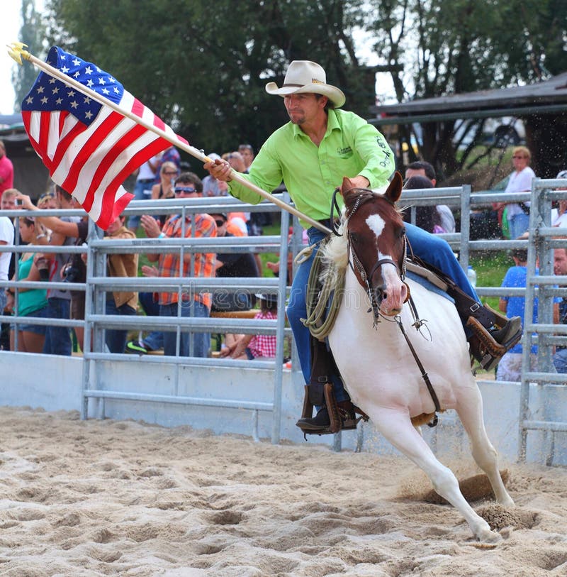 Unidentified Cowboy riding with American flag in a Opening ceremony at The International Rodeo Show Strabag Prorodeo Tour on August 24, 2013. Dnesice Halter Walley Czech Republic. Unidentified Cowboy riding with American flag in a Opening ceremony at The International Rodeo Show Strabag Prorodeo Tour on August 24, 2013. Dnesice Halter Walley Czech Republic.