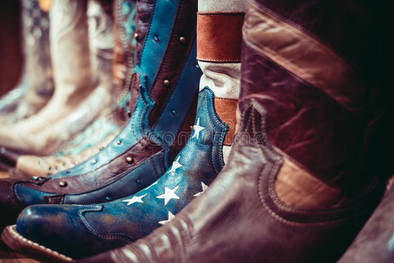 Cowboys boots on a shelf in a store with USA flag.