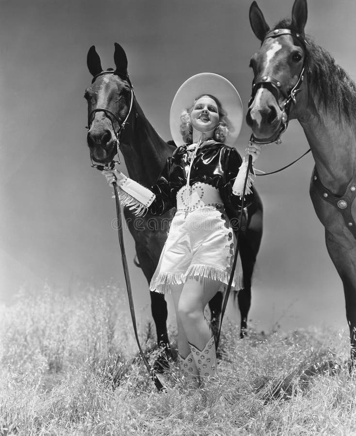 Cowgirl mit zwei Pferden lizenzfreies stockbild Cowgirl mit zwei Pferden lizenzfreies stockbild