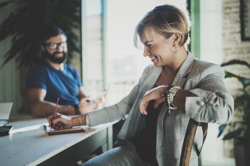 Coworkers working process at home.Young blonde woman working together with bearded colleague man at modern home office royalty free stock images Coworkers working process at home.Young blonde woman working together with bearded colleague man at modern home office royalty free stock images