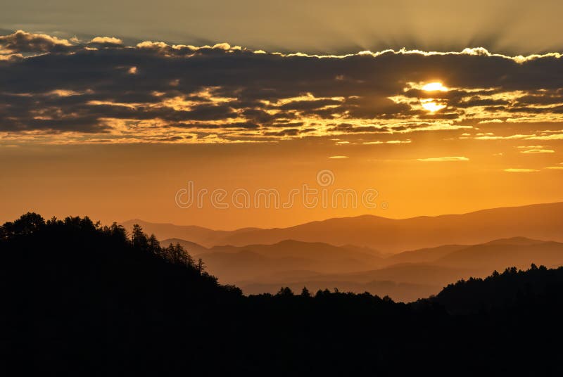 Mountain landscape silhouette at sunrise. Sun hidden behind the clouds. Vrsatec, Slovakia