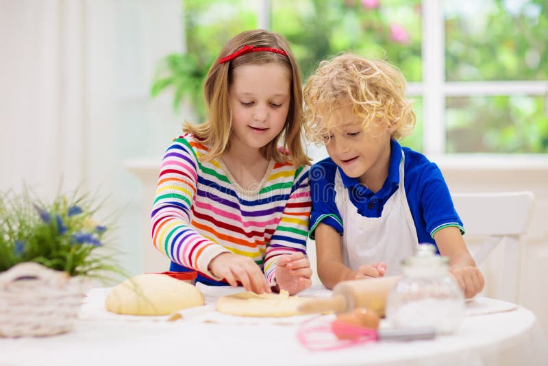 Cozedura infantil. crianças cozinhando na cozinha branca
